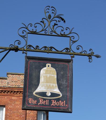 a sign that says the bell hotel with a bell holder at The Bell Hotel in Winslow