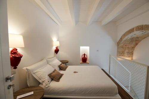 1 dormitorio con 1 cama en una habitación blanca en Iulius Suite & Spa en Conversano