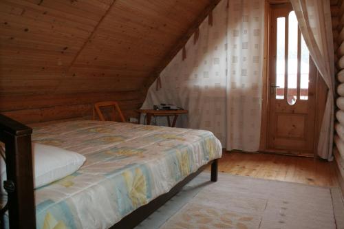 a bedroom with a bed and a wooden ceiling at Cottage Smerekovyi in Skole