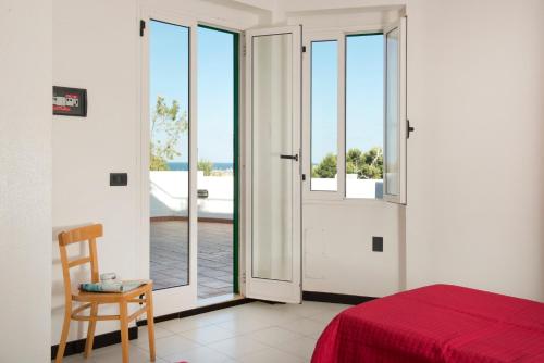 a bedroom with a door open to a balcony at Corvino Resort in Monopoli