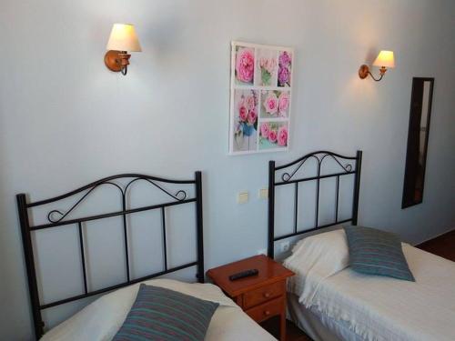2 camas en un dormitorio con 2 lámparas en la pared en Casa Maria Victoria, en Beja