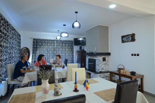 a group of people sitting at a table in a kitchen at Vila Madudu in Vălenii de Munte