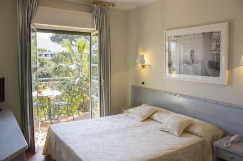 a bedroom with a bed and a large window at Hotel Mignon in Forte dei Marmi