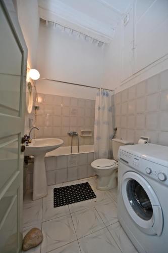 a bathroom with a washer and a sink and a washing machine at Apano Vrysi in Tinos