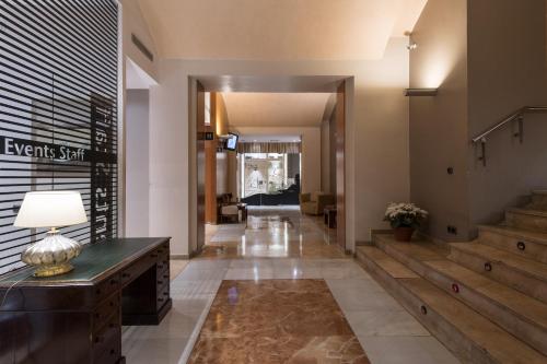 a hallway of a building with a desk and stairs at Catalonia Plaza Catalunya in Barcelona