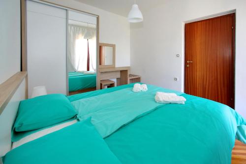 Un dormitorio con una cama azul con toallas. en Apartment Goga en Bibinje