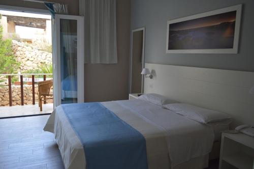 A bed or beds in a room at Le Anfore Hotel - Lampedusa