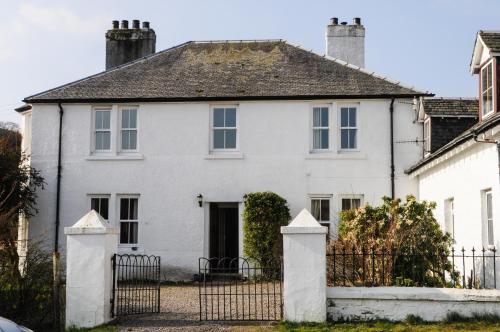 a white house with a gate in front of it at Cologin in Oban