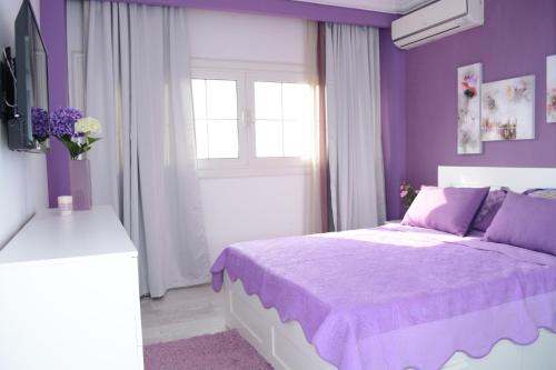 a purple bedroom with a bed and a window at Luxury Nile Maadi Cairo Apartment in Cairo