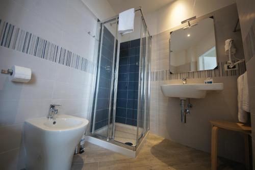 a bathroom with a sink and a shower and a toilet at Luna Rooms in Savona