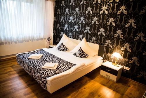 a bedroom with a bed with a black and white blanket at Villa Rynek in Góra Świętej Anny