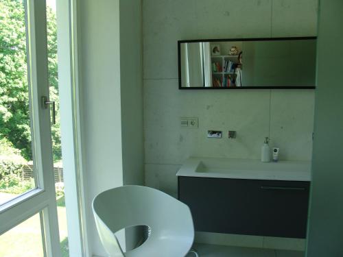 ein weißes Badezimmer mit einem Waschbecken und einem Spiegel in der Unterkunft Apartment Nürnberg in Nürnberg