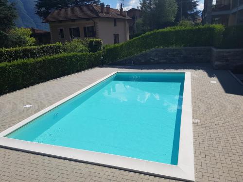 a large blue swimming pool in a yard at Casa Lella with pool and garden in Lenno