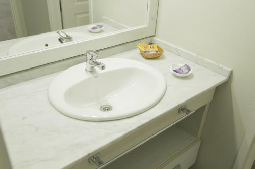 a bathroom with a white sink and a mirror at Links Apart Hotel in Río Grande