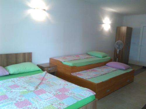 a room with three beds and a fan at Apartmani Lav in Sutomore
