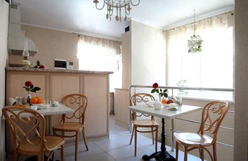 a kitchen with two tables and chairs in a room at Avantazh Hotel in Saratov