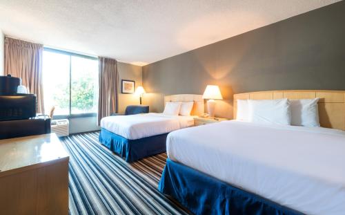 a hotel room with two beds and a window at Travelodge by Wyndham Memphis Airport/Graceland in Memphis