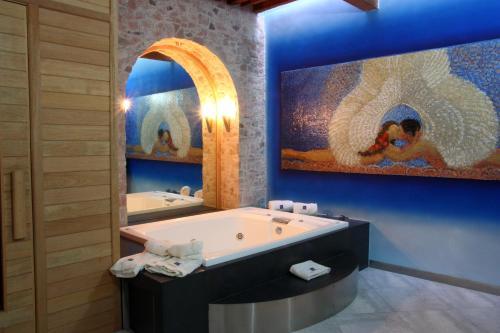 a bathroom with a large tub and a large painting at Casona de la Republica Hotel Boutique & SPA in Quer&eacute;taro