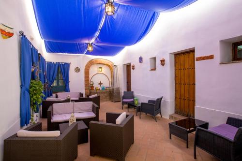 a restaurant with tables and chairs and a blue ceiling at Hospedería Convento de Santa Clara in Palma del Río