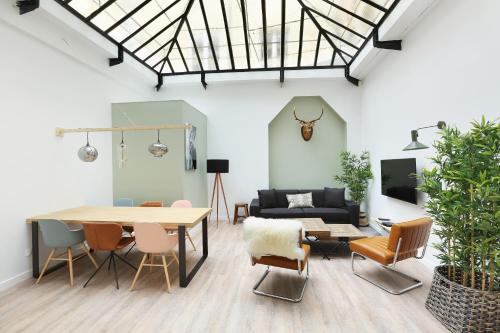 a living room with a table and chairs and a couch at Rent a Room - Residence Meslay in Paris
