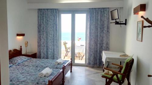 una camera da letto con un letto e vista sull'oceano di Hotel Theris a Megalochori (Isola di Agistri)