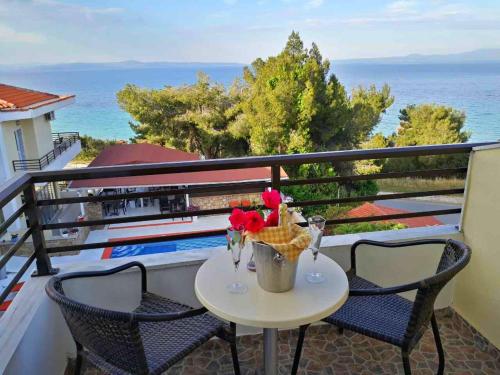 a table with flowers on a balcony with the ocean at Maya Bay in Kallithea Halkidikis