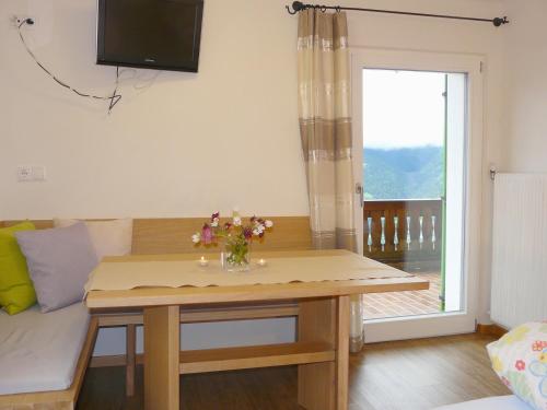 a living room with a table with flowers on it at B & B Apartments Ortlerblick in Sluderno