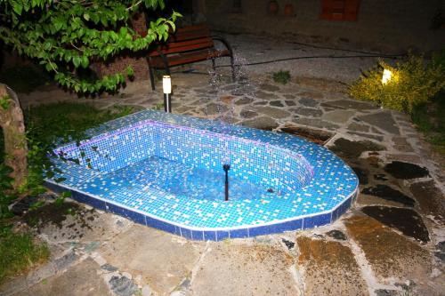 una piscina con azulejos azules en el suelo en Guest House Ivanovi, en Banya
