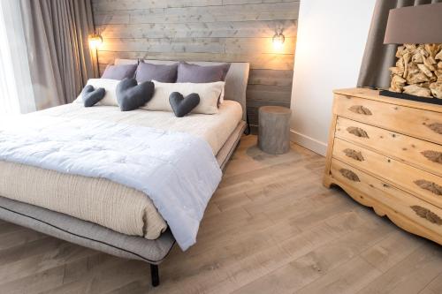 a bedroom with a bed with two blue hearts on it at 227 - En bordure de la rivière du Gouffre - Les Immeubles Charlevoix in Baie-Saint-Paul