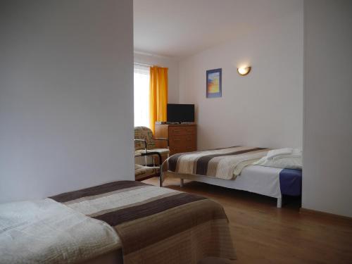 una habitación de hotel con 2 camas y una silla en Bursztyn, en Rewal