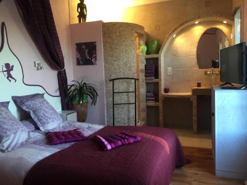 Un dormitorio con una cama con almohadas moradas. en Mas de la Croix en Saint-Christol-lès-Alès