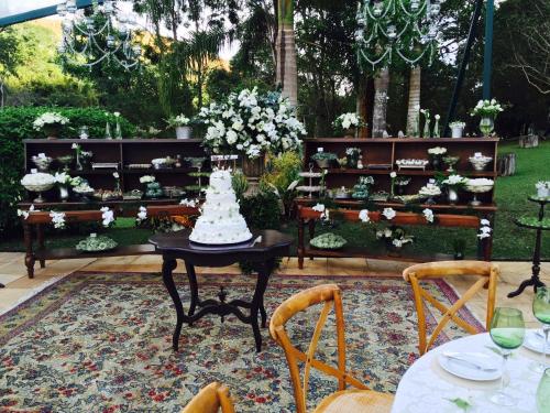 a table with a wedding cake on top of it at Pousada Les Roches in Itaipava