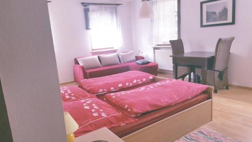 a living room with pink pillows and a couch at Pension-Puttlachtal in Pottenstein