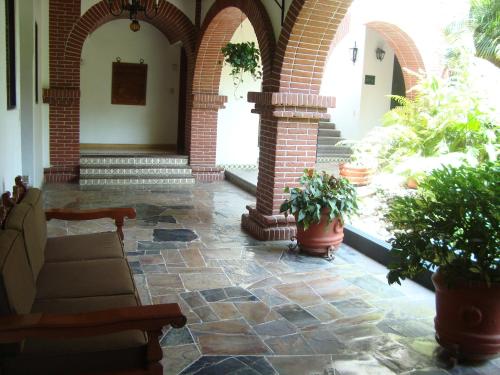 a lobby with a couch and potted plants at Hotel Vista Hermosa in Cuernavaca