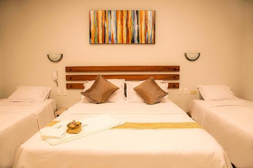 a bedroom with two beds and a picture on the wall at Sumaj Casa Hotel in Tarapoto