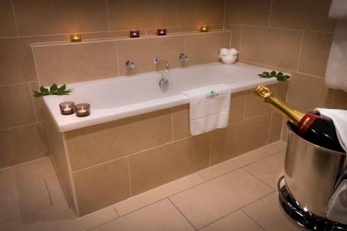 a bathroom with a bath tub with a bottle of champagne at Glencoe House in Glencoe