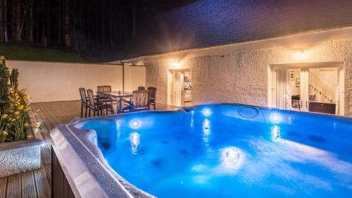 a large blue hot tub in a backyard at night at Glencoe House in Glencoe