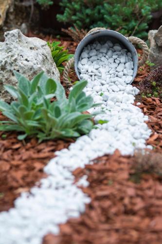 a bowl filled with white rocks in a garden at Moonriver Apartment in Veljun