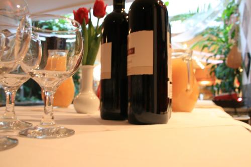 Pasha Hotel - 3* Boutique Hotel في لندن: طاولة مع زجاجات النبيذ واكواب النبيذ عليها