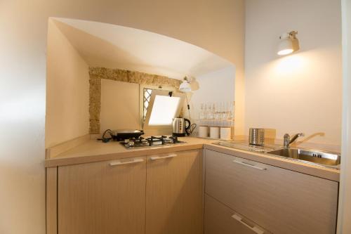 y cocina con fregadero y fogones. en Palazzo Taranto Luxury Rooms, en Caltagirone