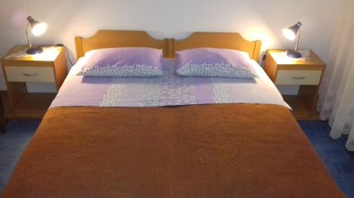 a bedroom with a bed with two lamps on two tables at Rooms Katija in Mali Ston