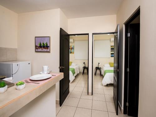 a bathroom with a sink and a room with two beds at Verona ApartHotel in Managua