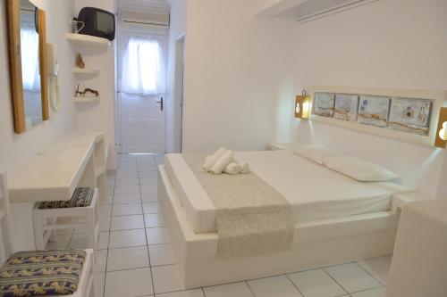a white bedroom with a bed and a sink at Hotel Apartments Giannis in Adamas