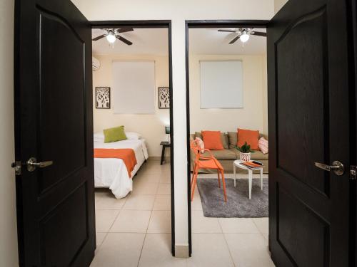 Verona ApartHotel في ماناغوا: غرفة نوم بسرير وغرفة بسرير واريكة