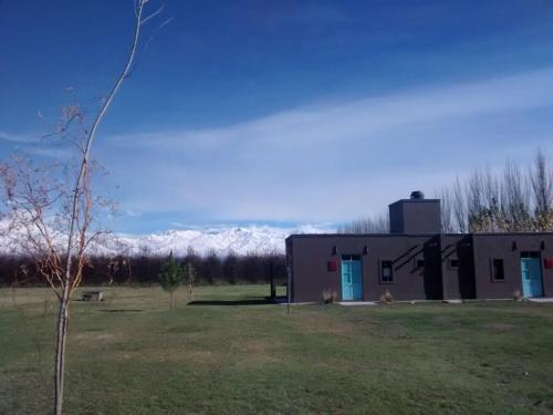 a building in a field with mountains in the background at Finca La Clementina in Tunuyán