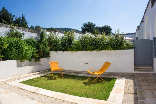 two orange chairs sitting on the grass in a yard at Masseria Capece in Cisternino