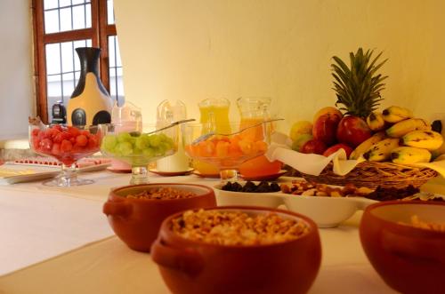 een tafel met kommen fruit en andere voedingsmiddelen bij Unaytambo Boutique Hotel Cusco in Cuzco