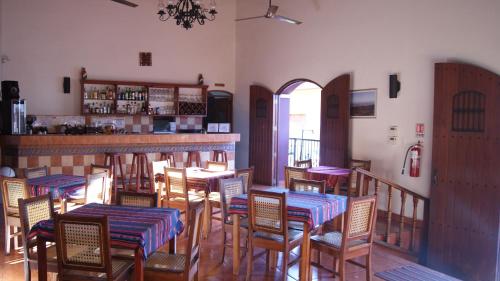 a restaurant with tables and chairs and a bar at Hotel Cacique Adiact in León