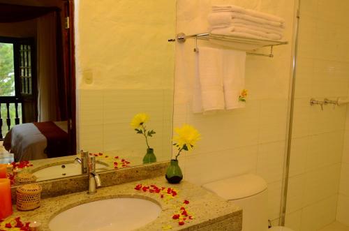 a bathroom with a sink and a shower with towels at Unaytambo Boutique Hotel Cusco in Cusco