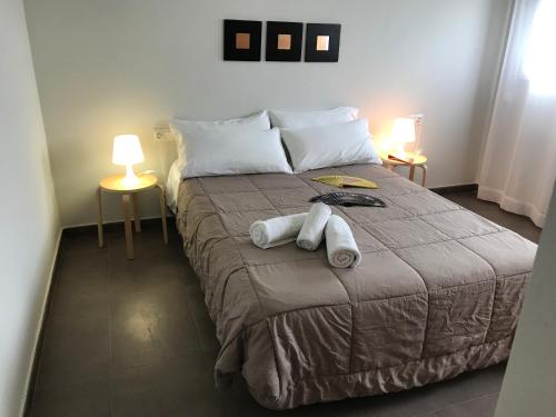 1 dormitorio con 1 cama grande y toallas. en Apartamentos Fercamar Denia, en Denia